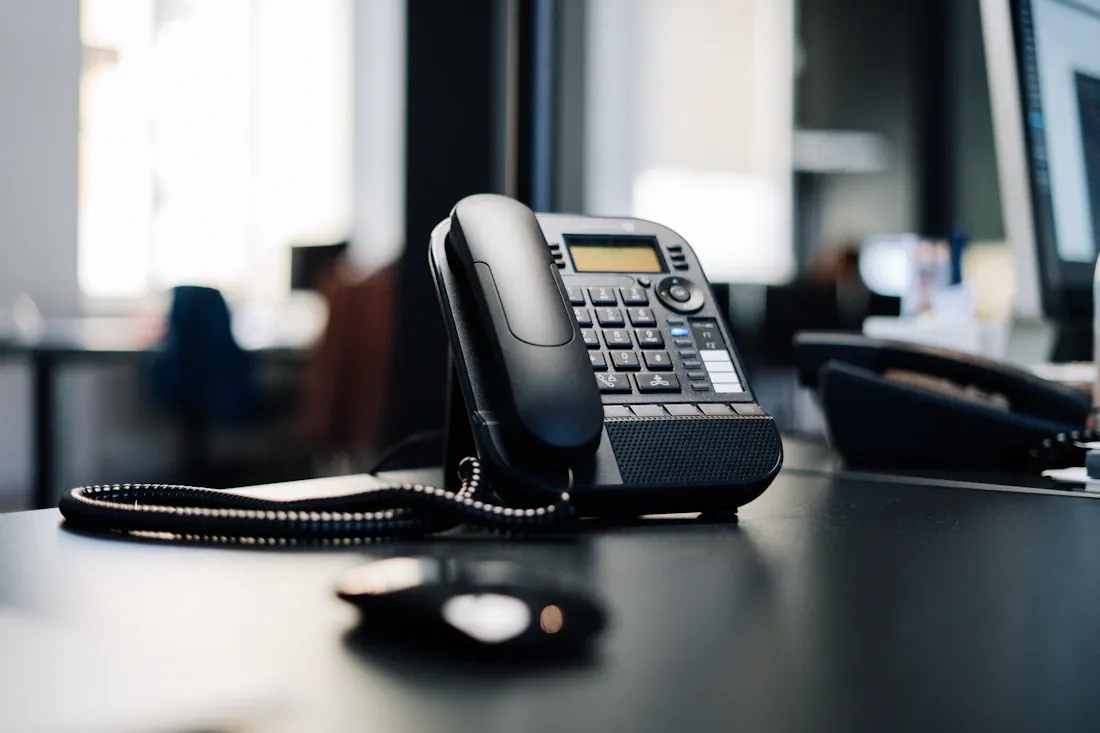 Téléphone de bureau posé sur une table dans un espace de travail.