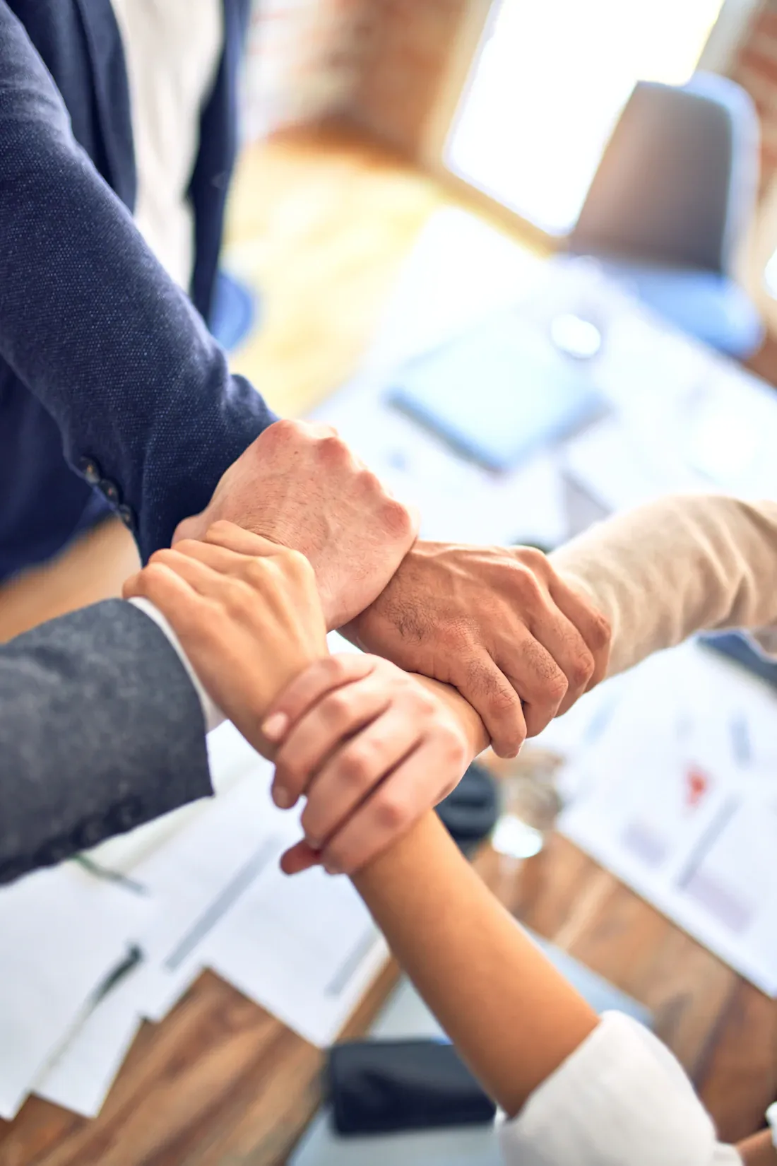 Poignée de main entre professionnels au-dessus de documents de travail.
